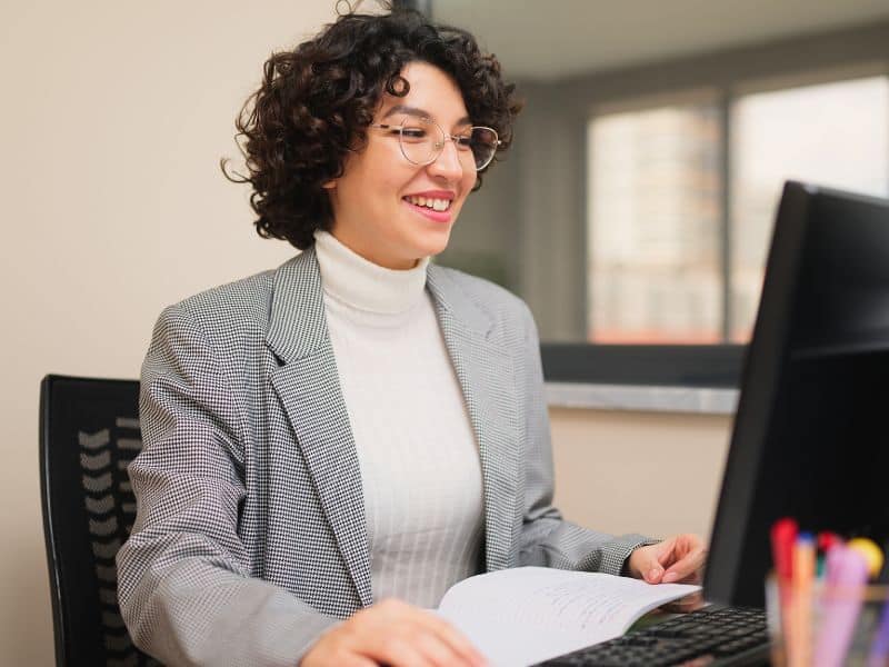 Woman working at a desk with a computer.