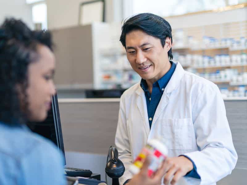 Pharmacist helping a patient pick up a medication
